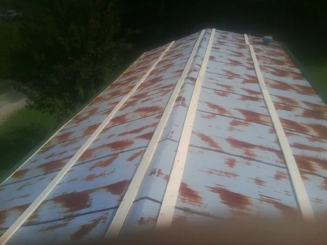 Rusted metal roof panels with new wood purlins before replacement — Storm Damage Roof Repair in Huffman by Roofing Brothers